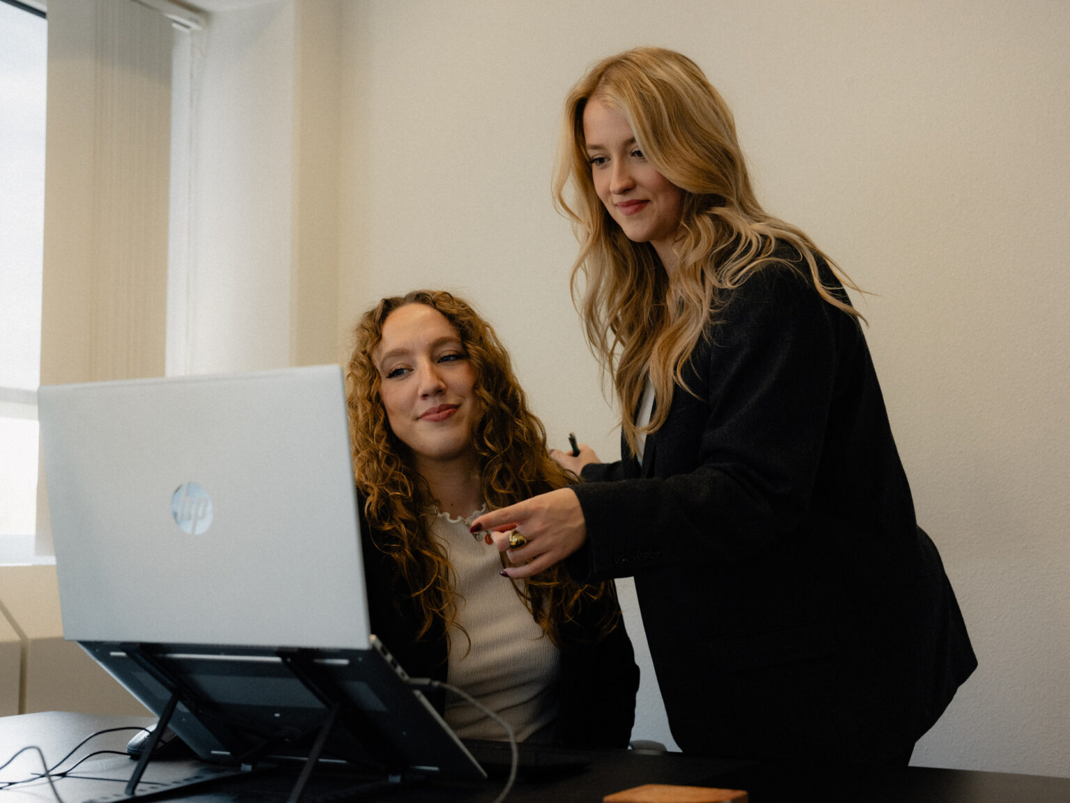 Twee collega's van Anivation bespreken een websiteproject achter de laptop