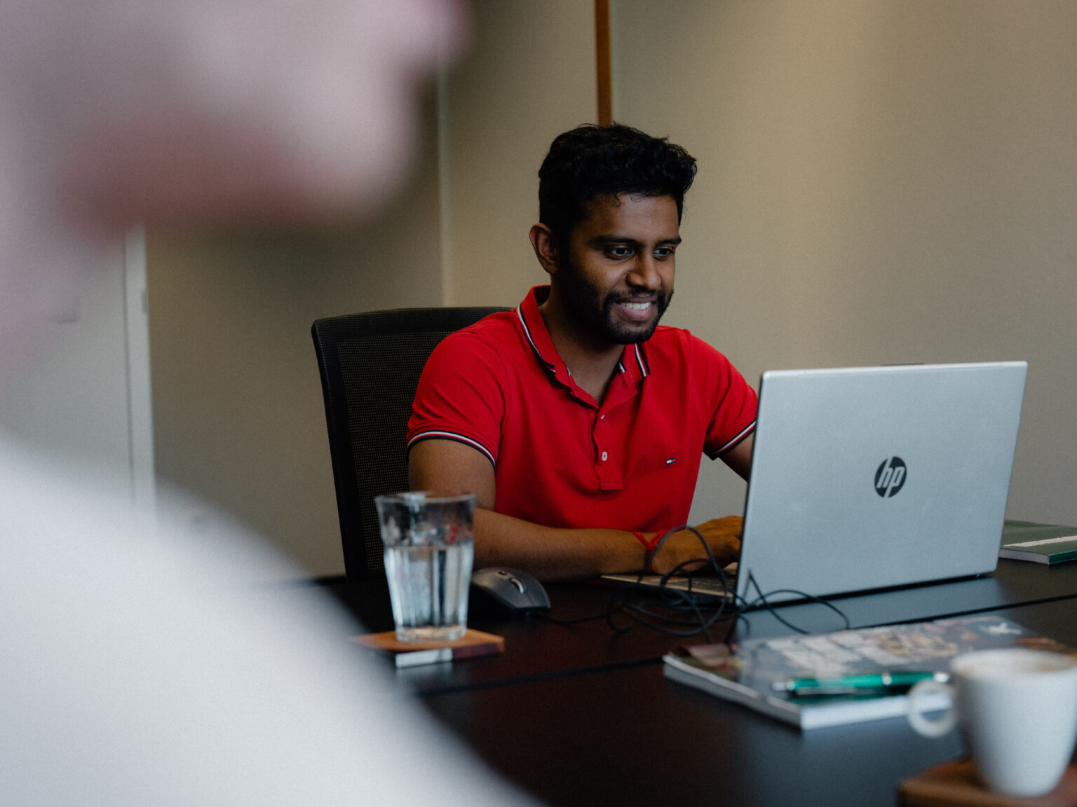 Collega van Anivation werkt op zijn laptop tijdens een overleg