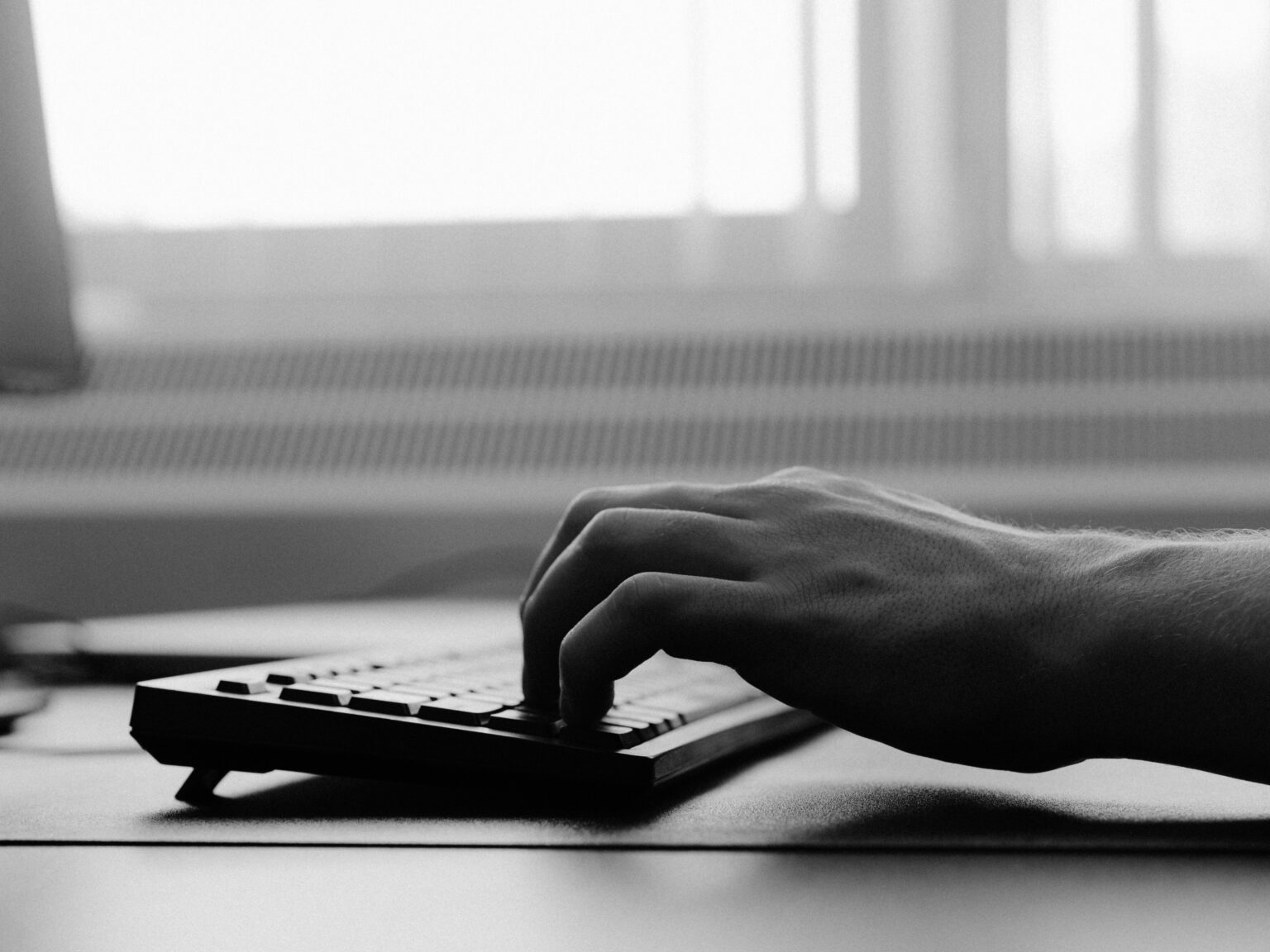 Hand op een toetsenbord tijdens het bouwen van een website